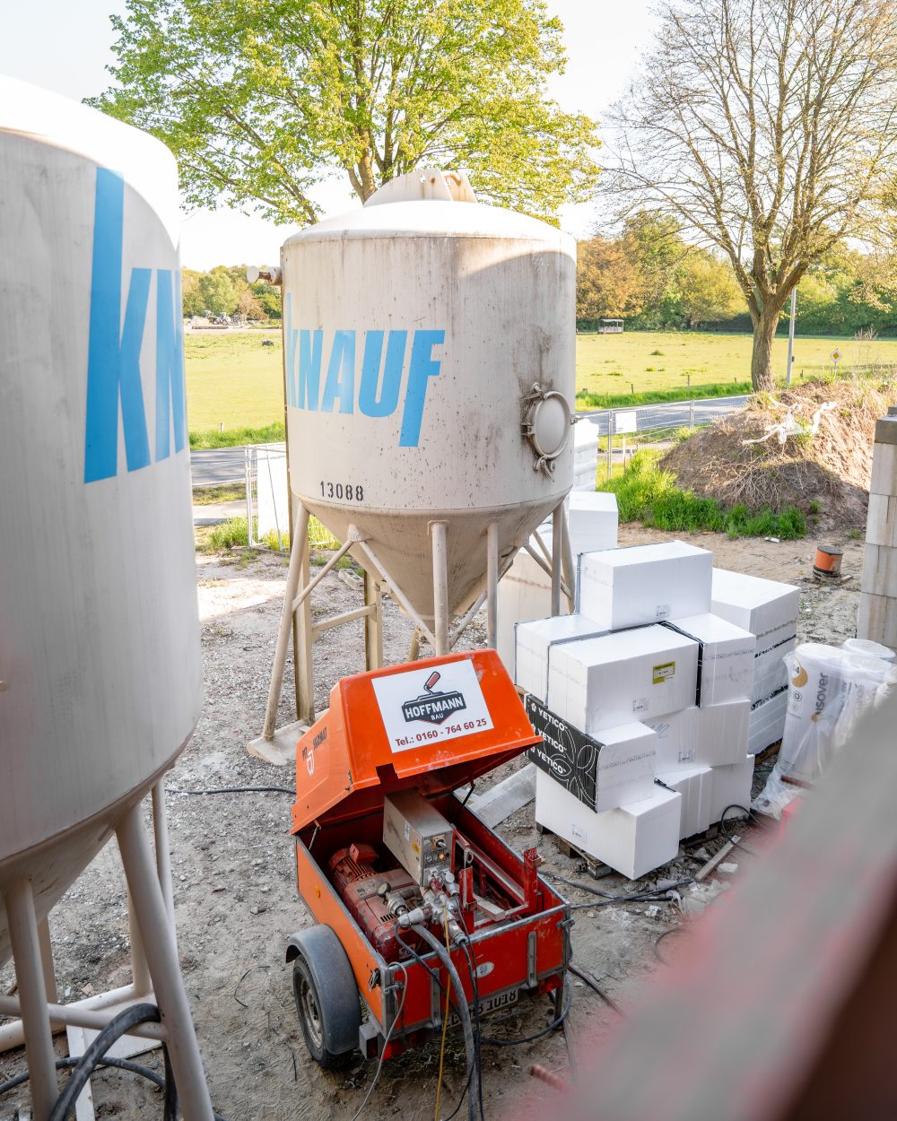 Putzmaschine von Hoffmann Bau neben Materialsilos auf der Baustelle