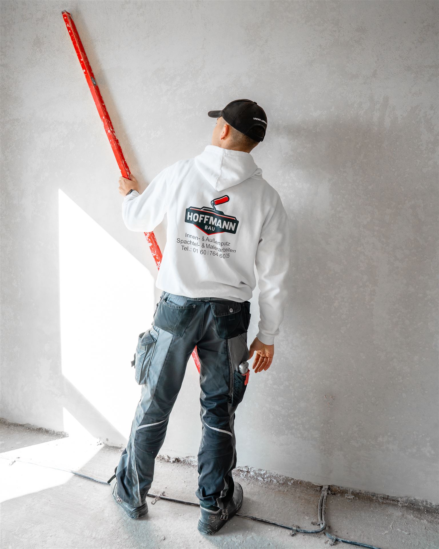 Hoffmann-Bau-Handwerker beim Nivellieren auf der Baustelle
