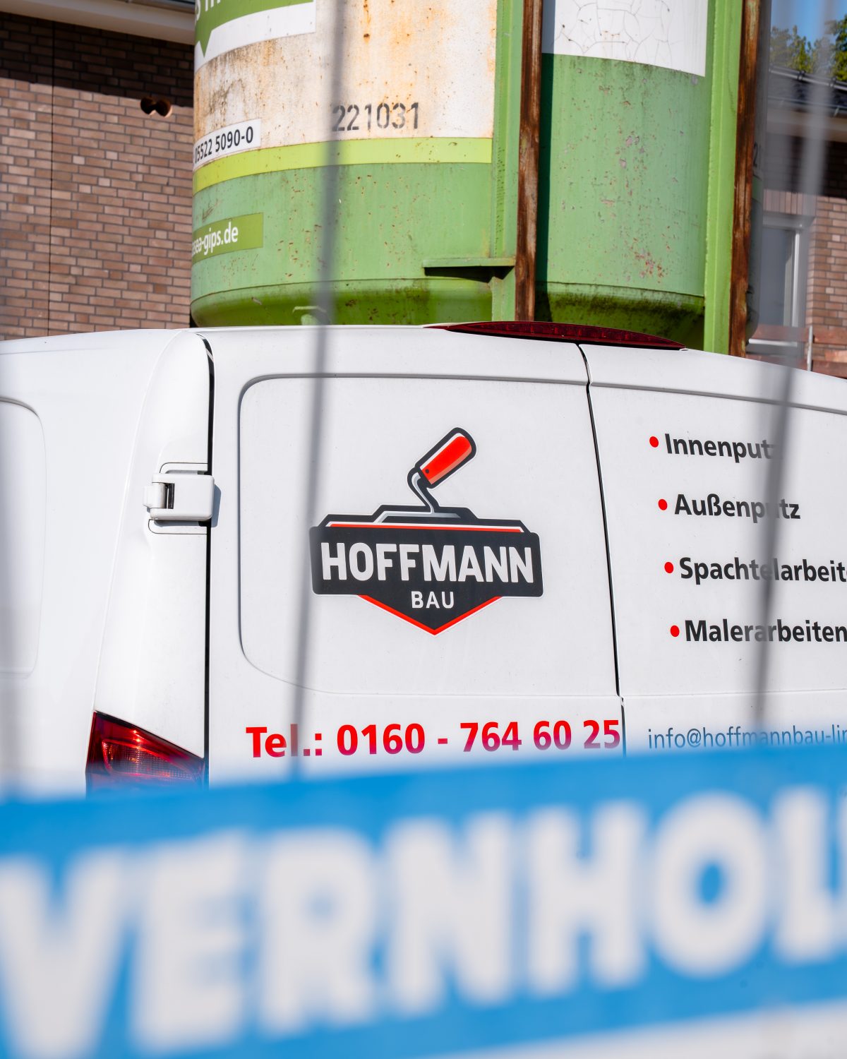 Firmenfahrzeug von Hoffmann Bau mit Logo und Leistungsübersicht